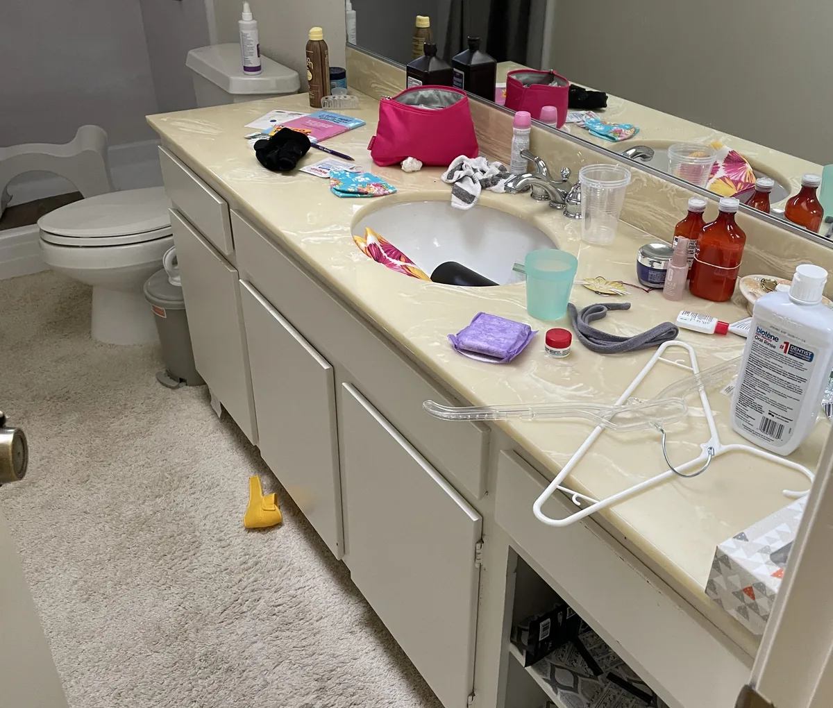 Bathroom vanity covered in leftover items in a vacated rental unit