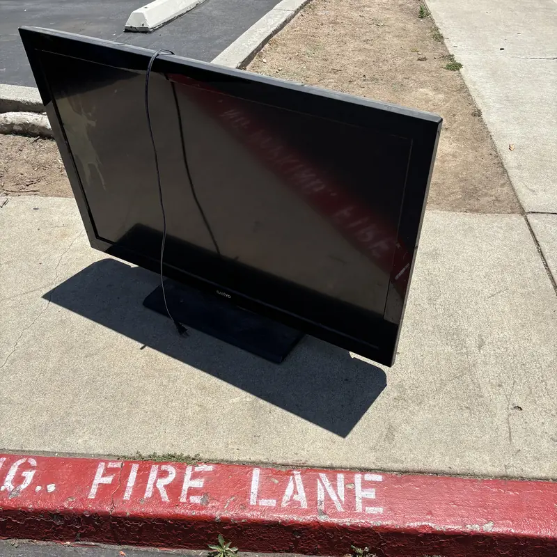 Large flat screen TV set out at the curb for e-waste pickup