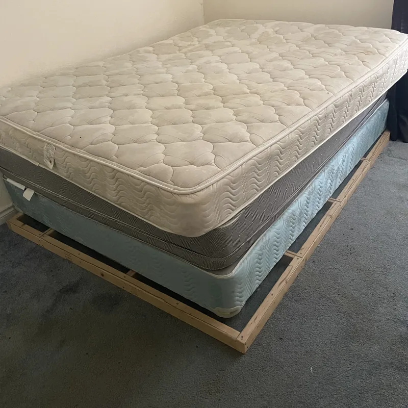 Mattress and box spring on a bed frame in an empty bedroom