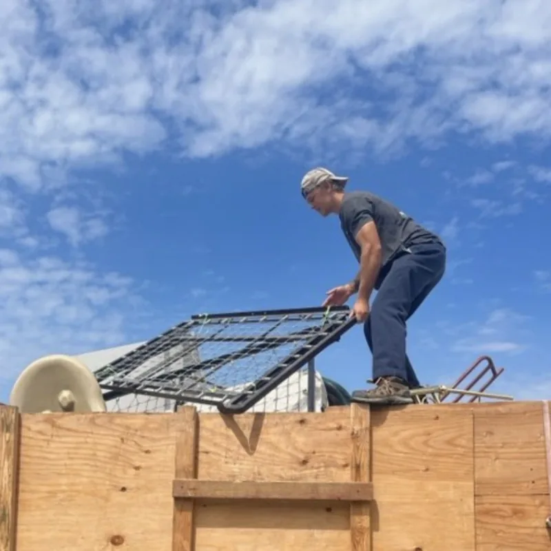 Scrap metal frame being loaded into the dump trailer